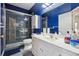 Modern bathroom with sleek white vanity, blue walls and tiled walk-in shower at 4440 Weston Sw Dr, Lilburn, GA 30047
