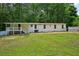 Expansive backyard view featuring a white home with a cozy covered porch and lush green lawn at 6201 Davids Se Way, Acworth, GA 30102