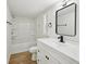 Modern bathroom with white vanity, black hardware, and tub with shower at 6201 Davids Se Way, Acworth, GA 30102