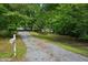 Long gravel driveway leading to a charming home surrounded by lush greenery and a mailbox at the entrance at 6201 Davids Se Way, Acworth, GA 30102