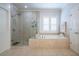 Bright bathroom features a tiled shower, a soaking tub with plantation shutters and updated fixtures at 1075 Bluffhaven Way Northeast Ne Way, Atlanta, GA 30319