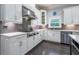 Modern kitchen boasts white cabinets, stainless steel appliances, and tiled backsplash, blending style and functionality at 1075 Bluffhaven Way Northeast Ne Way, Atlanta, GA 30319