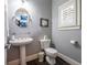 Well-lit powder room with a pedestal sink, a round mirror, and a window with shutter at 1075 Bluffhaven Way Northeast Ne Way, Atlanta, GA 30319