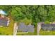 Beautiful aerial view of property featuring landscaped yard, pool, mature trees, and a neighboring home at 115 Creek Cir, Stockbridge, GA 30281
