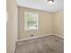 Neutral bedroom featuring a window providing natural light and plush carpeting at 115 Creek Cir, Stockbridge, GA 30281