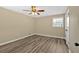 Bedroom with wood-look flooring, a ceiling fan, a window, and neutral paint at 115 Creek Cir, Stockbridge, GA 30281