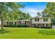 Charming two-story home with a brick and siding facade and a beautifully landscaped front yard under a sunny blue sky at 115 Creek Cir, Stockbridge, GA 30281