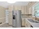 Kitchen with stainless steel refrigerator, light tile backsplash and light colored cabinets at 115 Creek Cir, Stockbridge, GA 30281