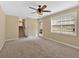 Spacious living room featuring plush carpeting, a ceiling fan, and access to a staircase at 115 Creek Cir, Stockbridge, GA 30281