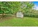 Lush backyard featuring a shed with light blue doors at 115 Creek Cir, Stockbridge, GA 30281
