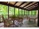 Cozy screened-in porch with wooden furniture and view of the surrounding trees at 2189 Cedar Forks Dr, Marietta, GA 30062