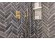 Detailed view of a modern shower featuring herringbone tile, a shower niche, and brass fixtures at 2189 Cedar Forks Dr, Marietta, GA 30062