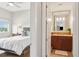 Bright bedroom featuring wood floors, a ceiling fan, and a well-lit bathroom with modern fixtures at 4561 Olde Perimeter Way # 806, Dunwoody, GA 30346