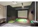 State-of-the-art golf simulator room with a projector screen and putting area for golf enthusiasts at 4561 Olde Perimeter Way # 806, Dunwoody, GA 30346