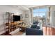 Comfortable living room featuring floor to ceiling windows, a blue sofa, and wood floors at 4561 Olde Perimeter Way # 806, Dunwoody, GA 30346