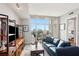 Bright living room featuring floor to ceiling windows and a comfortable blue leather sofa at 4561 Olde Perimeter Way # 806, Dunwoody, GA 30346