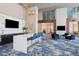 Bright lounge area with a marble island, seating, and multiple TVs at 4561 Olde Perimeter Way # 806, Dunwoody, GA 30346