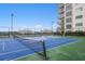 Outdoor blue and green tennis court, with a net, surrounded by mature trees on a sunny day at 4561 Olde Perimeter Way # 806, Dunwoody, GA 30346
