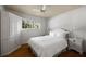 This stylish bedroom has bright white walls, a ceiling fan, and wooden floors at 1100 Tuxedo Dr, Roswell, GA 30075
