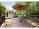 Wooden deck featuring an umbrella, outdoor seating, and views of the surrounding trees at 1100 Tuxedo Dr, Roswell, GA 30075