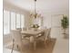 Elegant dining room with large windows, white shutters, chandelier, and seating for eight at 1100 Tuxedo Dr, Roswell, GA 30075
