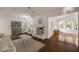 Cozy living room featuring hardwood floors, white fireplace, and views into sunroom at 1100 Tuxedo Dr, Roswell, GA 30075