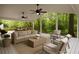 Inviting covered patio with comfortable seating, ceiling fans, and view of the wooded landscape at 1100 Tuxedo Dr, Roswell, GA 30075