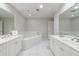 Bright bathroom featuring double vanities, soaking tub, and all white finishes with ample lighting at 50 Biscayne Nw Dr # 4110, Atlanta, GA 30309