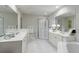 Elegant bathroom featuring double vanities, glass enclosed shower, soaking tub, and white tile flooring at 50 Biscayne Nw Dr # 4110, Atlanta, GA 30309
