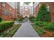 Beautiful courtyard of a brick apartment building with landscaped flower beds and walkway to the main entrance at 50 Biscayne Nw Dr # 4110, Atlanta, GA 30309