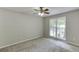 Cozy bedroom featuring neutral paint, carpet floors, ceiling fan and a large window at 5930 Bridle Dr, Cumming, GA 30028
