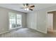 Comfortable carpeted bedroom with neutral paint, ceiling fan, closet, and natural light streaming through the window at 5930 Bridle Dr, Cumming, GA 30028