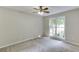 Bright bedroom with neutral walls, carpet, a ceiling fan, and a double window providing natural light at 5930 Bridle Dr, Cumming, GA 30028