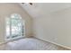 Cozy bedroom with vaulted ceiling, carpet, and a large window allowing for ample natural light at 5930 Bridle Dr, Cumming, GA 30028