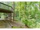 Multi-level deck with stairs leading to the secluded backyard, surrounded by lush trees and vegetation at 5930 Bridle Dr, Cumming, GA 30028