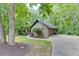 Side view of home with a lush lawn, mature trees, and a long driveway leading to the attached garage at 5930 Bridle Dr, Cumming, GA 30028