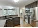 Modern kitchen with stainless appliances, dark cabinets, breakfast bar, and easy access to laundry at 5930 Bridle Dr, Cumming, GA 30028