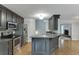 Well-equipped kitchen featuring stainless steel appliances, dark cabinets, breakfast bar, and open layout at 5930 Bridle Dr, Cumming, GA 30028