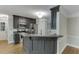 Stylish kitchen with stainless steel appliances, dark cabinetry, breakfast bar, and hardwood floors at 5930 Bridle Dr, Cumming, GA 30028