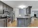 Kitchen with stainless steel appliances, granite countertops, gray cabinets, and hardwood flooring at 5930 Bridle Dr, Cumming, GA 30028