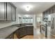 Well-lit kitchen featuring stainless steel appliances, dark cabinets, breakfast bar, and ample counter space at 5930 Bridle Dr, Cumming, GA 30028