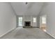 Spacious living room with a cozy stone fireplace, neutral paint, plush carpeting, and plenty of natural light at 5930 Bridle Dr, Cumming, GA 30028