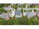An aerial view shows the back of the house with a wooden deck and lush green trees and landscaping at 1565 Briergate Dr, Duluth, GA 30097