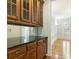 Butler pantry with granite countertop, mirrored backsplash, and wood cabinets at 1565 Briergate Dr, Duluth, GA 30097