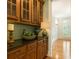 Charming butler's pantry with dark granite countertops and rich wooden cabinetry for ample storage at 1565 Briergate Dr, Duluth, GA 30097