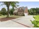 Long driveway leading to a brick home with a columned front porch and a three-car garage at 1565 Briergate Dr, Duluth, GA 30097