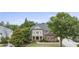 Brick home with a covered porch and balcony, set amid lush greenery and trees on a well-manicured lawn at 1565 Briergate Dr, Duluth, GA 30097