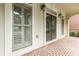 Inviting front porch with brick flooring, classic columns, exterior lighting and double doors with windows at 1565 Briergate Dr, Duluth, GA 30097