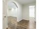 Hallway featuring an arched entryway and wood flooring that flows into a walk-in closet at 1565 Briergate Dr, Duluth, GA 30097