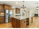 Kitchen island with granite countertop, wooden cabinets, and a view to the staircase and fireplace at 1565 Briergate Dr, Duluth, GA 30097